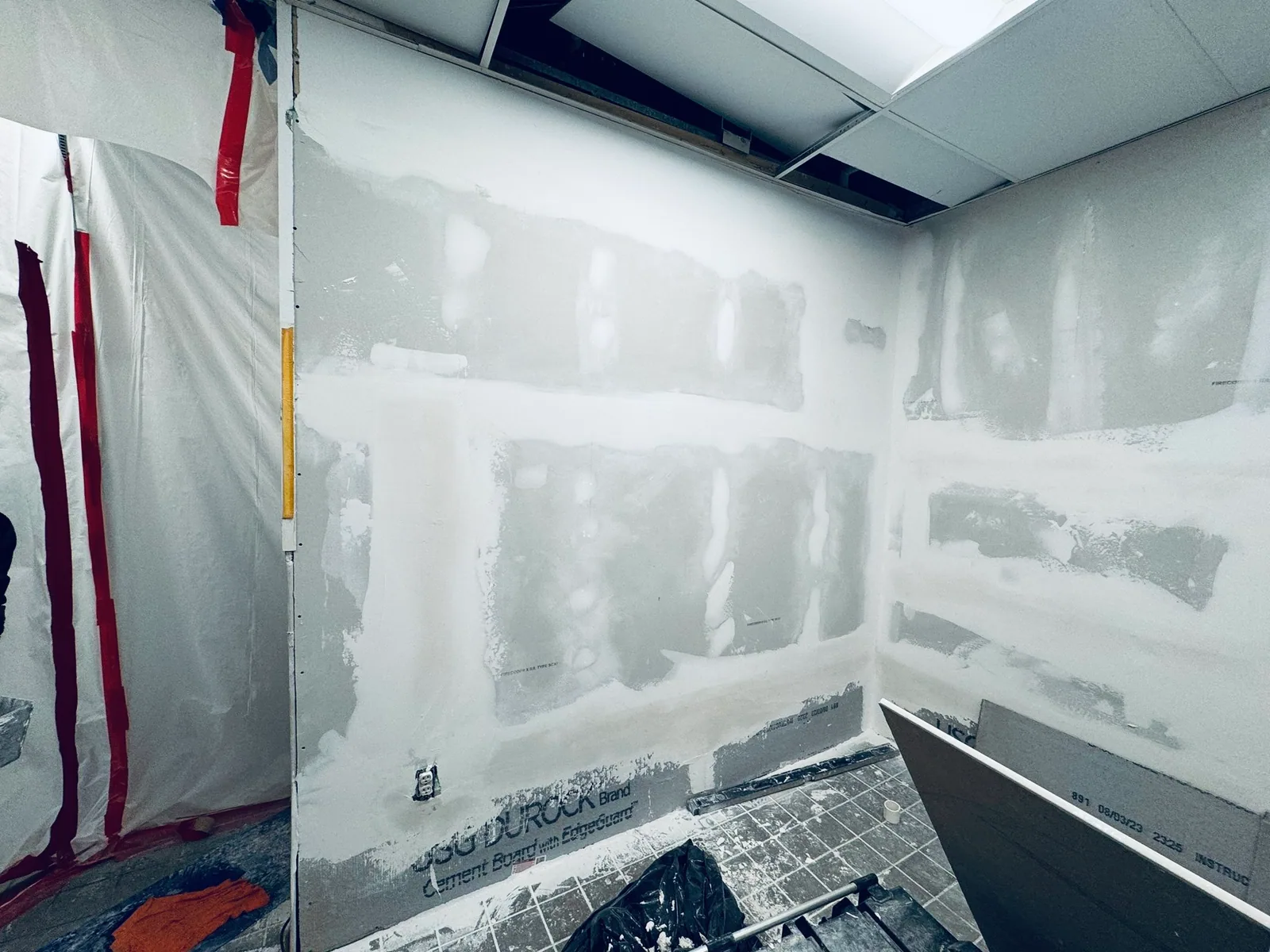 Patched walls and containment sheeting inside a work area