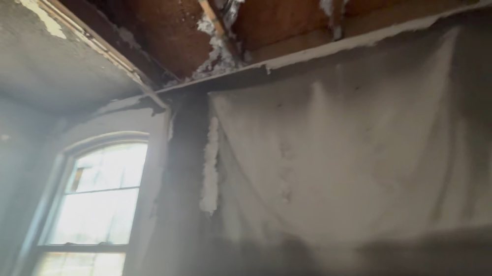Techo dañado y pared manchada al lado de una ventana