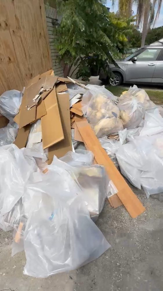 Escombros en bolsas y piezas de madera fuera de un edificio