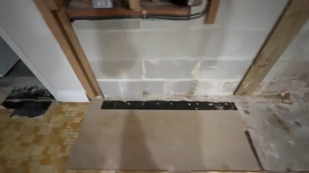 Open lower wall with exposed framing beside tile flooring