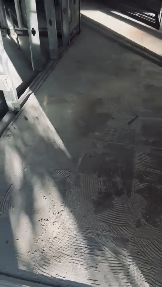 Bare floor beside exposed wall framing