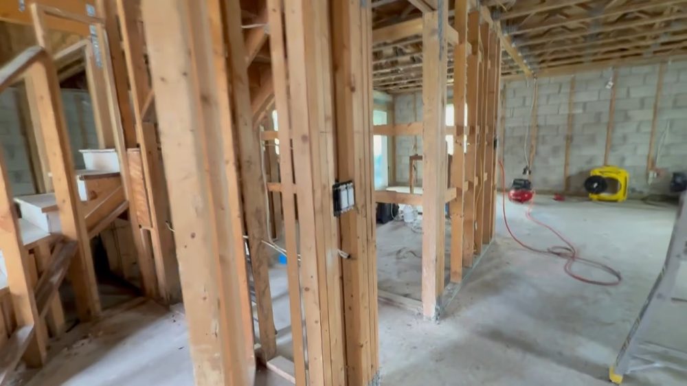 Exposed wall studs with equipment and cables on the floor