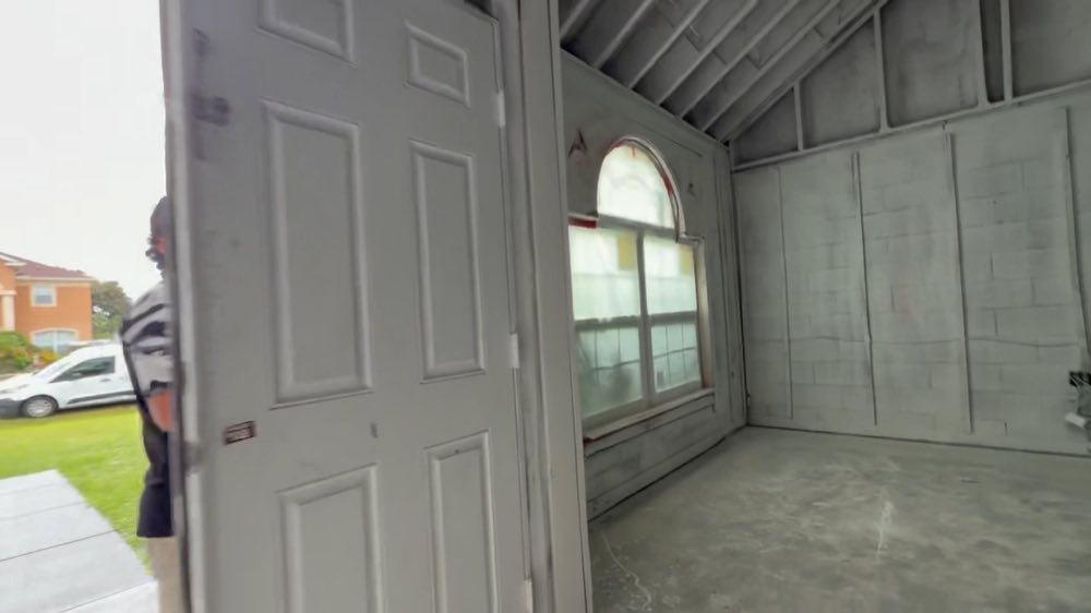Open doorway into a room with exposed framing