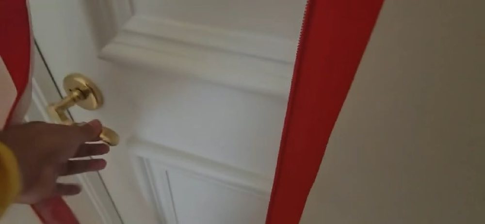 Hand reaching toward a door handle beside red containment tape