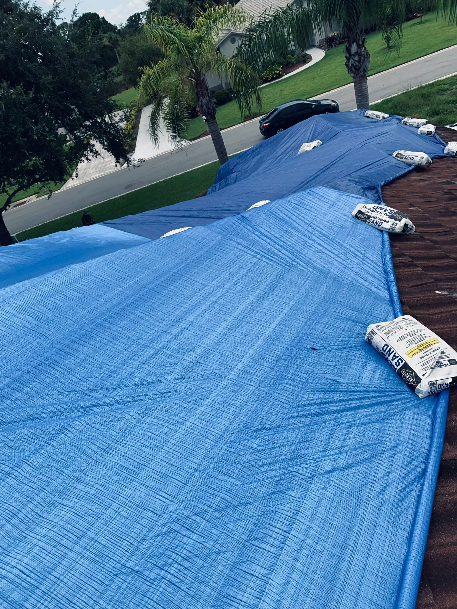 Blue tarp secured along a residential roof