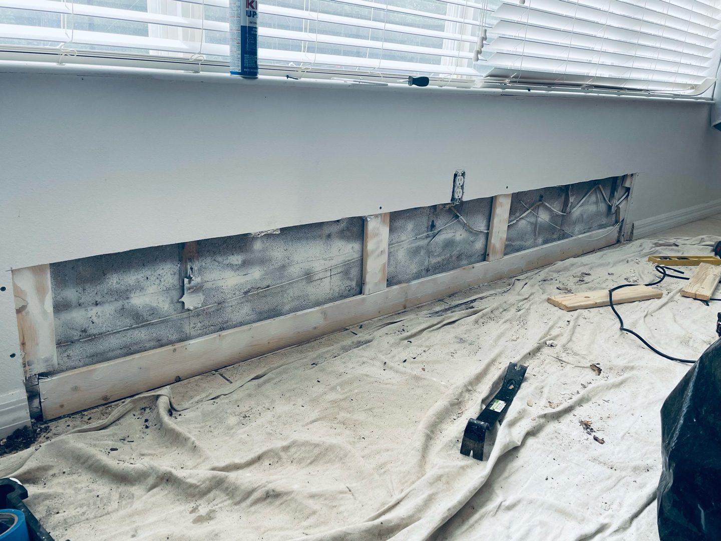 Se quitó la pared inferior debajo de una ventana, dejando al descubierto el marco y las manchas oscuras