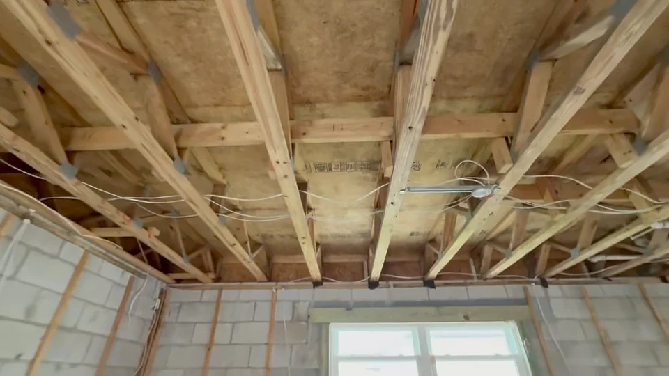 Exposed wooden ceiling joists and wiring