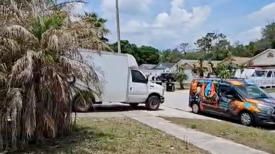 Hugo-branded vehicle and white service truck outside a home